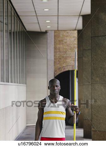 Man holding javelin outside building View Large Photo Image Picture - Man holding javelin outside building. Fotosearch
