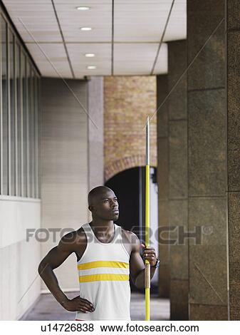 Man holding javelin outside building View Large Photo Image Stock Photo - Man holding javelin outside building. Fotosearch