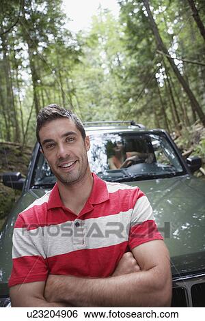 Man in front of car in forest portrait View Large Photo Image Stock Photograph - Man in front of car in forest portrait. Fotosearch