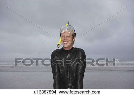 Man in wetsuit wearing snorkle standing on beach portrait View Large Photo Image Picture - Man in wetsuit wearing snorkle standing on beach portrait. Fotosearch