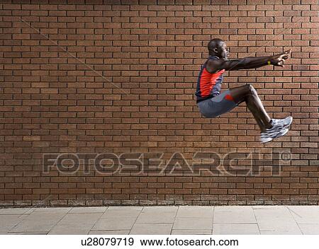 Man jumping by wall View Large Photo Image Stock Photo - Man jumping by wall. Fotosearch