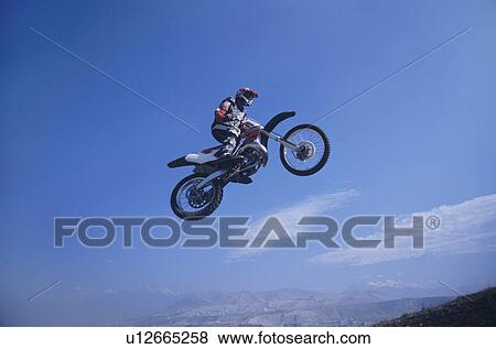Stock Photo - Man jumping on motorbike. Fotosearch