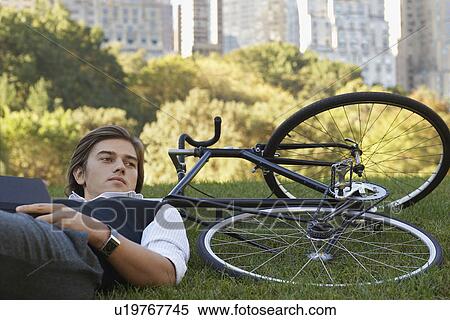 Man leaning against bicycle on lawn View Large Photo Image Stock Photography - Man leaning against bicycle on lawn. Fotosearch