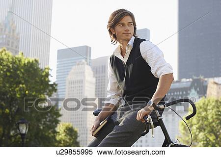 Stock Photography - Man leaning on bicycle. Fotosearch