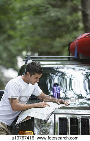 Man observing map on car bonnet View Large Photo Image Stock Photograph - Man observing map on car bonnet. Fotosearch