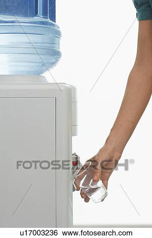 Man pouring drink from water cooler indoors close-up of arm and hand View Large Photo Image Stock Photograph - Man pouring drink from water cooler indoors close-up of arm and hand. Fotosearch