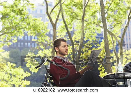 Man reading newspaper in park View Large Photo Image Stock Image - Man reading newspaper in park. Fotosearch