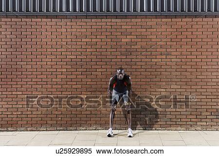 Stock Photography - Man resting by wall. Fotosearch
