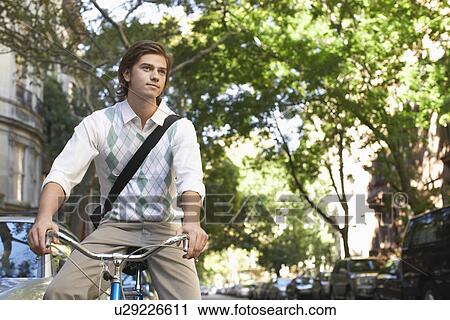 Man riding bicycle in residential district View Large Photo Image Stock Image - Man riding bicycle in residential district. Fotosearch