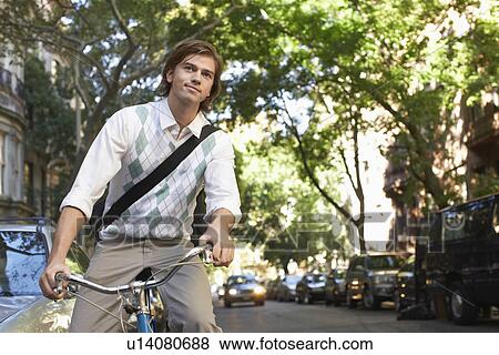 Man riding bicycle in residential district View Large Photo Image Stock Photo - Man riding bicycle in residential district. Fotosearch