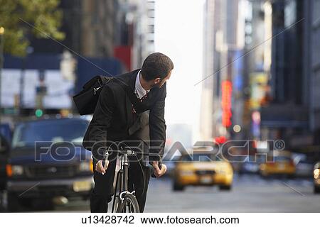 Man riding bicycle on street View Large Photo Image Stock Image - Man riding bicycle on street. Fotosearch