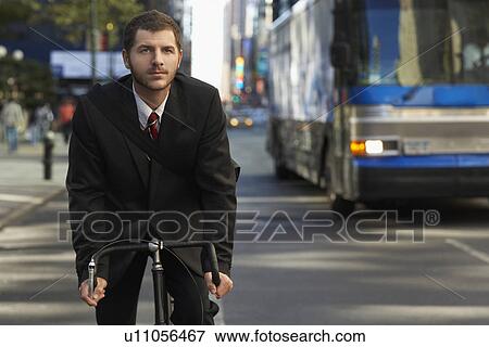 Man riding bicycle on street View Large Photo Image Stock Photo - Man riding bicycle on street. Fotosearch