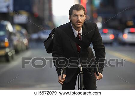 Man riding bicycle on street View Large Photo Image Stock Photo - Man riding bicycle on street. Fotosearch