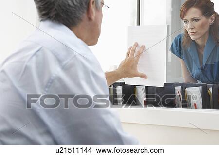 Man showing woman paper in office View Large Photo Image Picture - Man showing woman paper in office. Fotosearch
