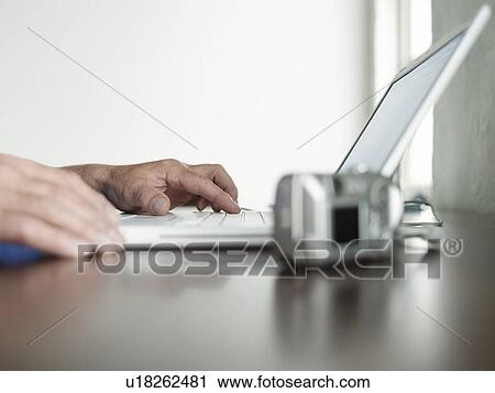 Man sitting at desk using laptop side view close-up of hands View Large Photo Image Stock Image - Man sitting at desk using laptop side view close-up of hands. Fotosearch
