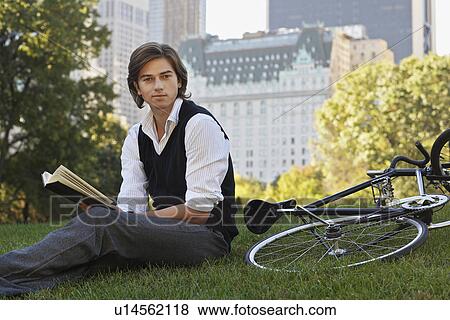 Man sitting on lawn holding book portrait View Large Photo Image Stock Photo - Man sitting on lawn holding book portrait. Fotosearch