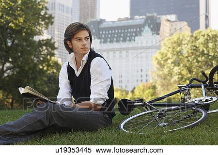 Man sitting on lawn holding book View Large Photo Image Stock Photography - Man sitting on lawn holding book. Fotosearch