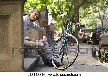 Stock Photograph - Man sitttng on stone steps. Fotosearch