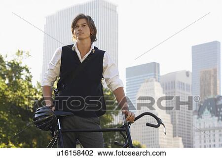 Man standig at bicycle View Large Photo Image Stock Image - Man standig at bicycle. Fotosearch