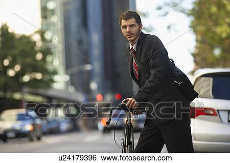 Man standing by bicycle in street portrait View Large Photo Image Stock Photograph - Man standing by bicycle in street portrait. Fotosearch