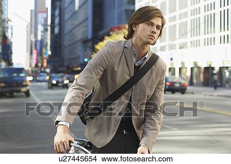 Man standing by bicycle on busy street View Large Photo Image Picture - Man standing by bicycle on busy street. Fotosearch