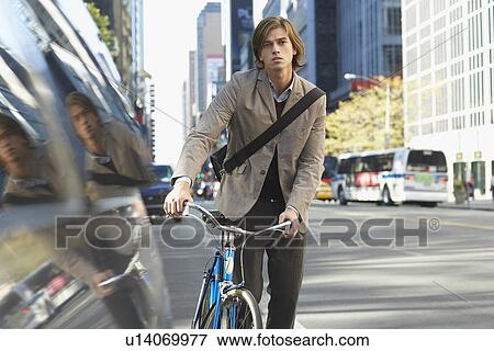 Man standing by bicycle on busy street portrait View Large Photo Image Stock Photo - Man standing by bicycle on busy street portrait. Fotosearch