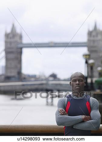 Stock Image - Man standing in front of Tower Bridge England London. Fotosearch