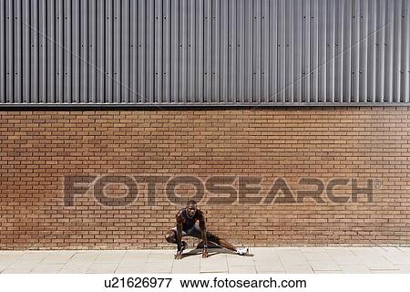 Stock Photo - Man stretching by wall. Fotosearch