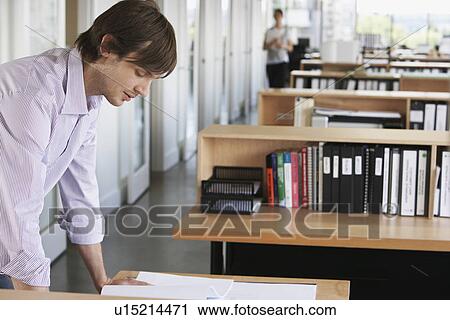 Man studying blueprint in office View Large Photo Image Stock Image - Man studying blueprint in office. Fotosearch