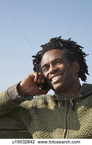 Man talking on mobile phone outdoors View Large Photo Image Stock Image - Man talking on mobile phone outdoors. Fotosearch
