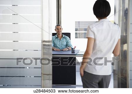 Man talking to woman standing in doorway of his office View Large Photo Image Stock Image - Man talking to woman standing in doorway of his office. Fotosearch