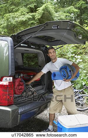 Man unloading car in countryside View Large Photo Image Stock Photography - Man unloading car in countryside. Fotosearch