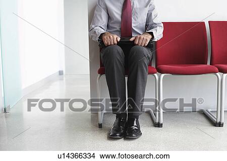 Man waiting on chair in corridor low section View Large Photo Image Picture - Man waiting on chair in corridor low section. Fotosearch