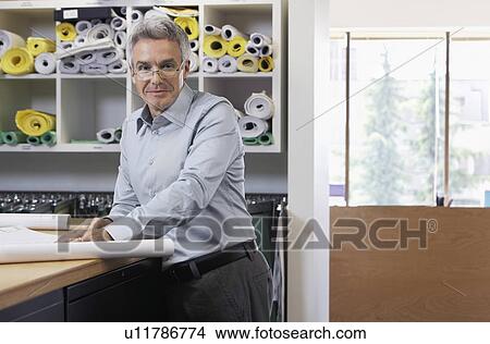 Picture - Man with paperwork in office portrait. Fotosearch