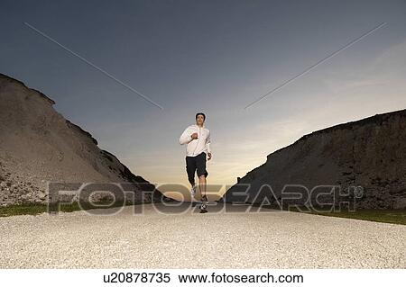 Mid adult man jogging in evening View Large Photo Image Stock Photography - Mid adult man jogging in evening. Fotosearch