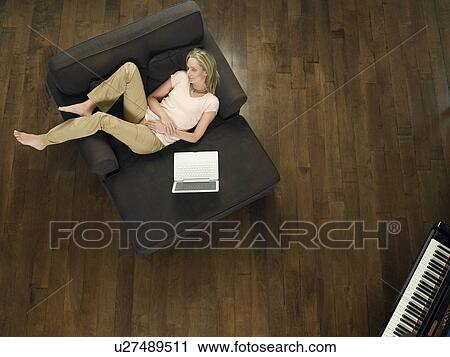 Mid adult woman sleeping on sofa laptop beside view from above View Large Photo Image Stock Image - Mid adult woman sleeping on sofa laptop beside view from above. Fotosearch
