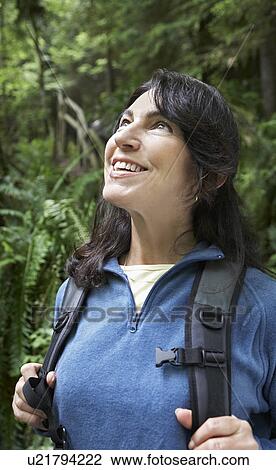 Middle-aged woman in forest looking up smiling View Large Photo Image Stock Image - Middle-aged woman in forest looking up smiling. Fotosearch