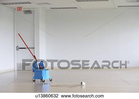 Mop in pail by spilled coffee mug in empty room View Large Photo Image Stock Image - Mop in pail by spilled coffee mug in empty room. Fotosearch