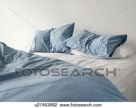 Morning view of an unmade bed with crumpled blue bed linens and no people View Large Photo Image Stock Image - Morning view of an unmade bed with crumpled blue bed linens and no people. Fotosearch