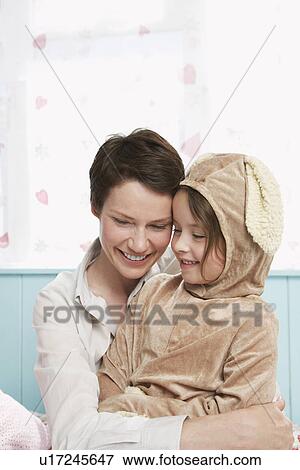 Mother and daughter (5-6) embracing and smiling girl in bunny costume View Large Photo Image Stock Photo - Mother and daughter (5-6) embracing and smiling girl in bunny costume. Fotosearch