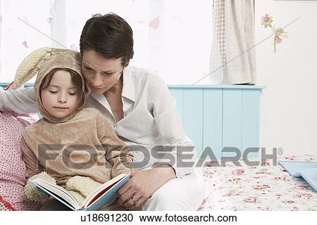 Mother and daughter (5-6) in bedroom reading book girl in bunny costume View Large Photo Image Stock Image - Mother and daughter (5-6) in bedroom reading book girl in bunny costume. Fotosearch