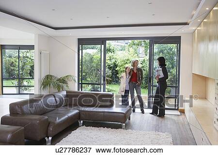 Stock Photo - Mother and daughter (7-9) with estate agent in new property. Fotosearch
