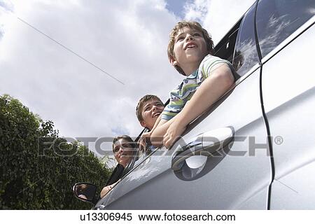 Mother and two boys (5-11) leaning out car window low angle view View Large Photo Image Stock Photography - Mother and two boys (5-11) leaning out car window low angle view. Fotosearch
