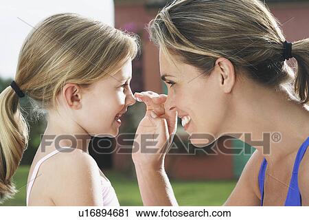 Mother applying sunscreen on daughter's (5-6) nose smiling side view profile View Large Photo Image Stock Image - Mother applying sunscreen on daughter's (5-6) nose smiling side view profile. Fotosearch