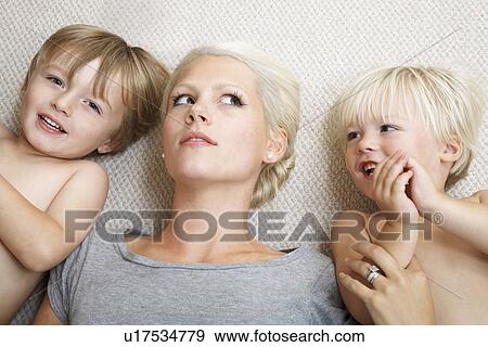 Mother lying with boys (2-4) on floor View Large Photo Image Stock Photo - Mother lying with boys (2-4) on floor. Fotosearch