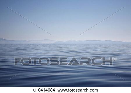 Picture - Ocean with hazy mountain shore. Fotosearch
