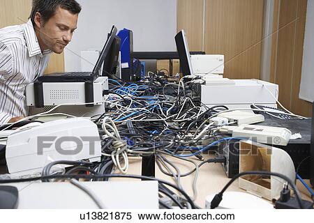 Office worker looking at mess of wires connecting computers and printer in office View Large Photo Image Stock Photography - Office worker looking at mess of wires connecting computers and printer in office. Fotosearch
