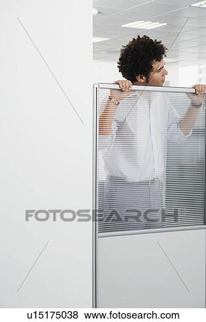 Office worker peering over cubicle wall View Large Photo Image Stock Photo - Office worker peering over cubicle wall. Fotosearch