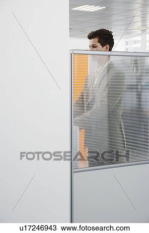 Office worker standing behind cubicle wall View Large Photo Image Stock Image - Office worker standing behind cubicle wall. Fotosearch