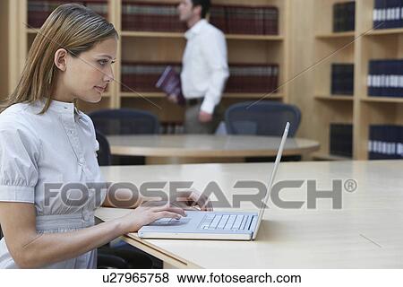 Office worker using laptop in legal office side view View Large Photo Image Stock Photo - Office worker using laptop in legal office side view. Fotosearch